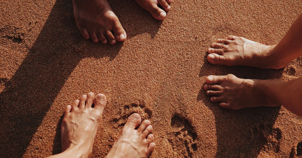 Pés descalços sobre uma superfície de areia